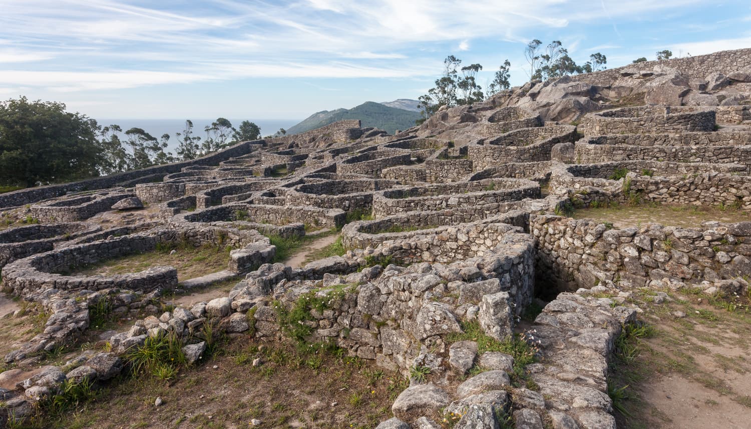 Round stone house foundations of the Santa Trega castro on a hillside above the Atlantic