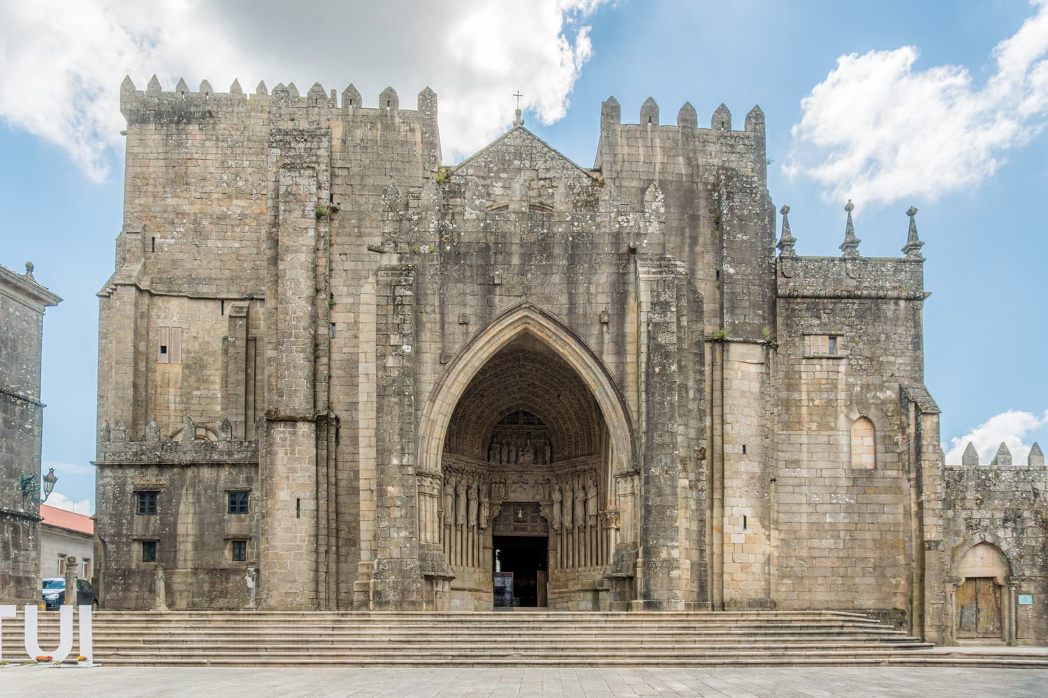 The fortified granite façade and Gothic portal of Tui cathedral