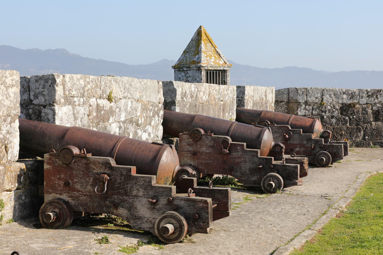 Old iron cannons on a battery of Monterreal fortress, looking out over the bay