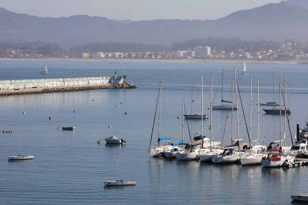 Yachts moored in Baiona’s harbour with the bay and the far shore behind